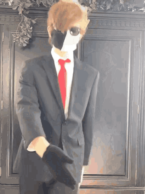 a man in a suit and tie with a mask on his face .