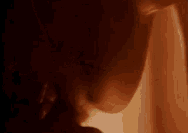 a close up of a person 's face in a dark room with a blurred background .