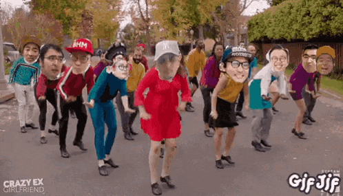 a group of people are dancing on a street with their faces on their heads .
