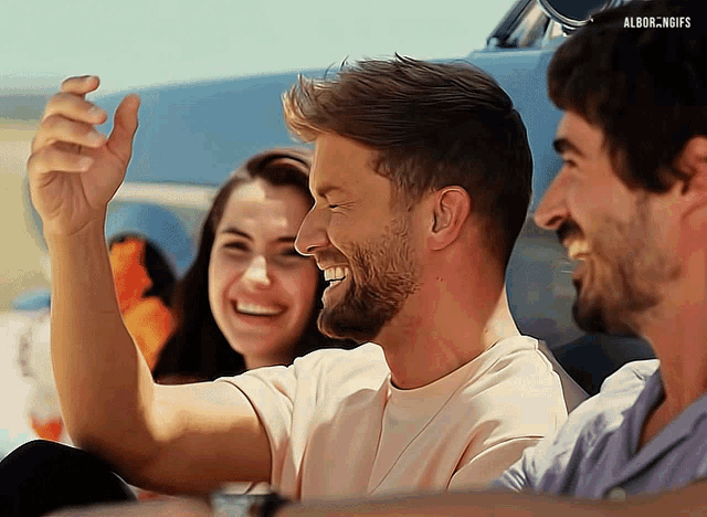 a group of people are laughing and one of them is wearing a white shirt that says albor.ngifs
