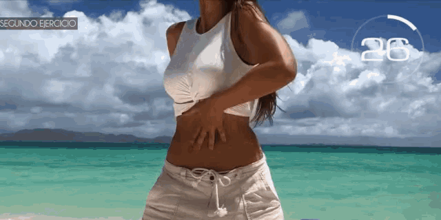 a woman standing on a beach with the number 26 on the bottom