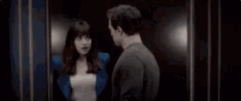 a man and a woman are kissing in a dark room in a movie .