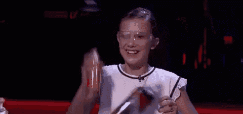 a young girl wearing goggles is holding a bottle of liquid in her hand .