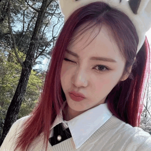 a woman with red hair wearing a white headband