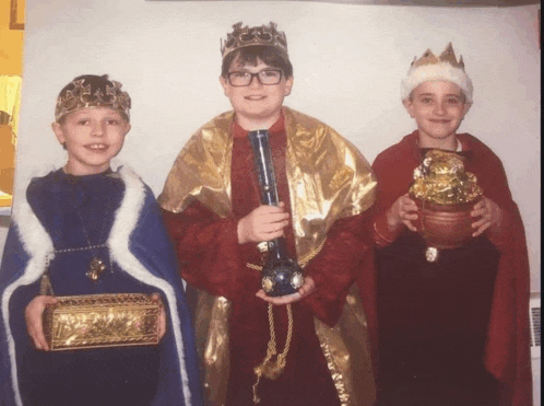 three boys dressed as the three wise men holding gifts