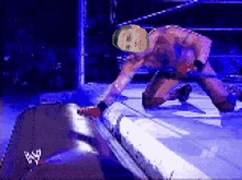 a man in a wrestling ring with a w logo on the bottom right