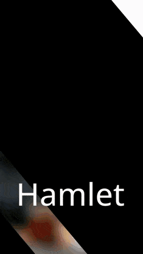 a man with a beard sits at a table with a cup of tea and the word hamlet on the bottom right