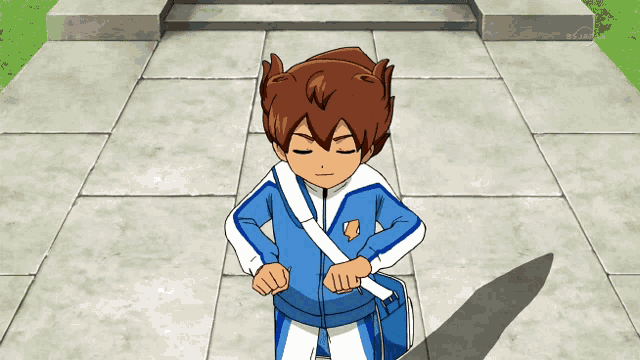 a boy in a blue and white outfit stands on a sidewalk