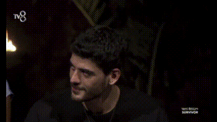 two men are standing next to each other in a dark room and smiling for the camera .