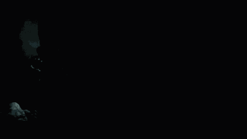 a man holding a sword in the dark