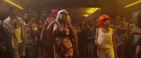 a group of people are dancing in a club and one of the women is pregnant .