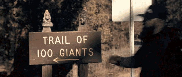 a sign for the trail of 100 giants with an arrow pointing to the right