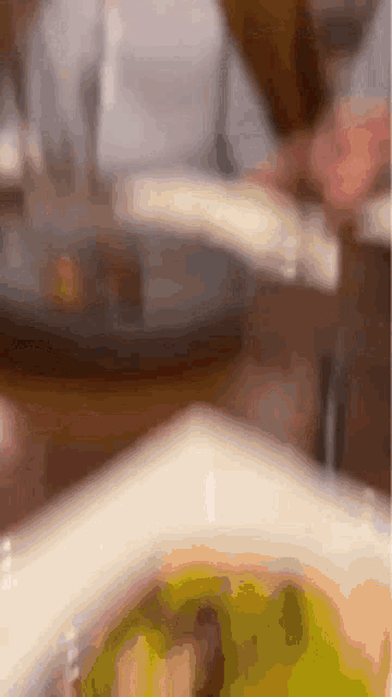 a close up of a plate of food on a table with a person in the background