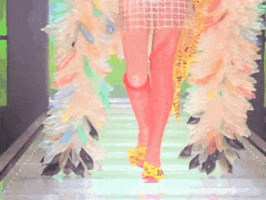 a woman is walking down a runway wearing a colorful costume with the word n on it