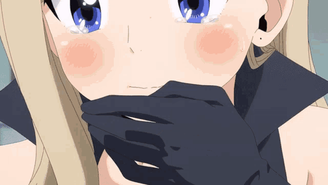 a blonde girl with blue eyes is covering her mouth with her hand
