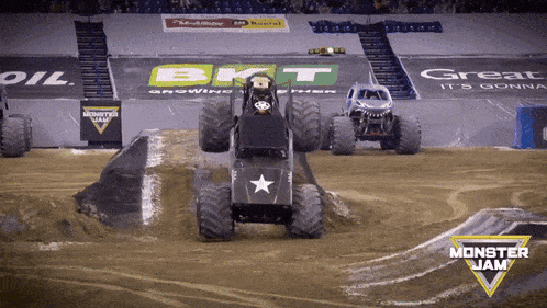 two monster jam trucks are on a track