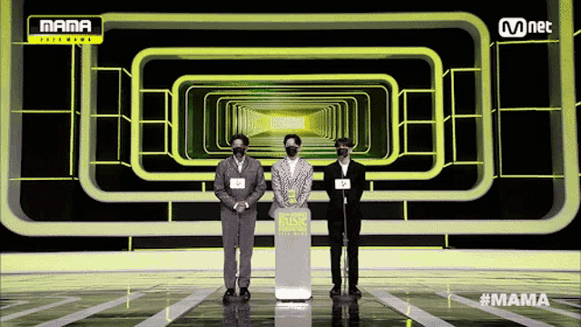three men wearing masks stand in front of a podium that says mama