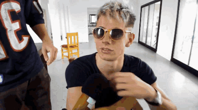 a man wearing sunglasses and a shirt that says e on it