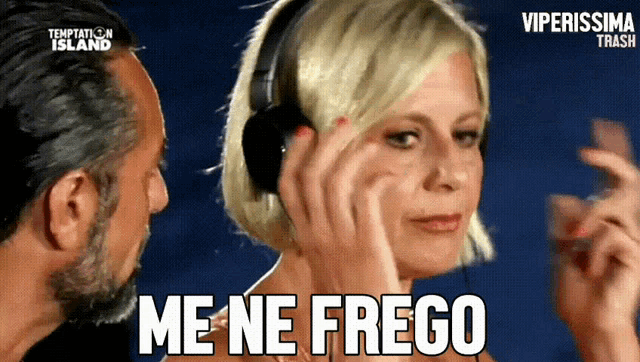 a woman wearing headphones says " me ne frego " next to a man