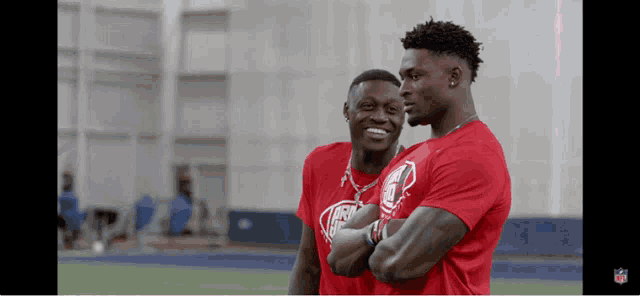 two men in red shirts with the nfl logo on them