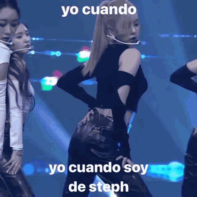 a woman in a black top and leather pants is dancing on a stage with a microphone .