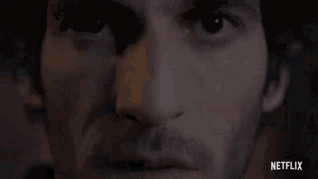 a close up of a man 's face in a dark room with a netflix logo in the corner .
