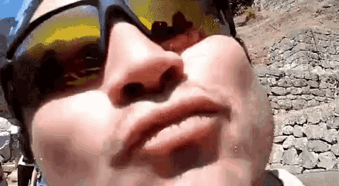 a close up of a person wearing sunglasses making a funny face