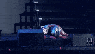 a man in a superhero costume is laying on the stage