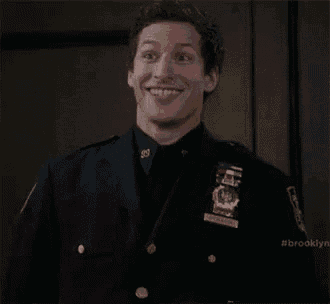 a man in a police uniform is smiling while standing in a room .