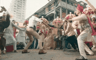 a group of people are dancing on the street with umbrellas