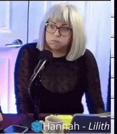 a woman wearing a wig and glasses is sitting in front of a microphone with the name hannah lilith on the bottom