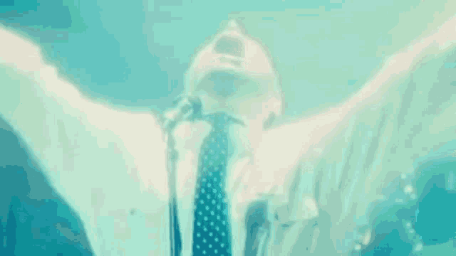 a man in a suit and tie is singing into a microphone .