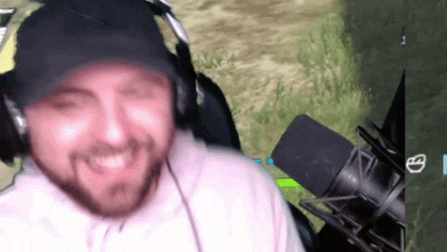 a man wearing headphones and a hat is playing a video game .