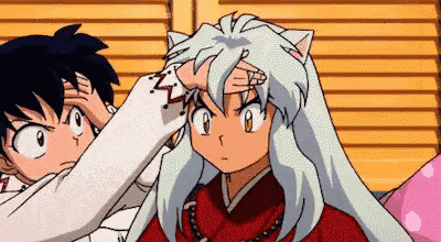 a person is touching another person 's head with their hand .