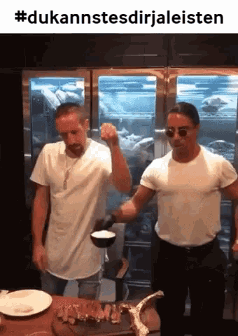 two men in white shirts are pouring liquid into a bowl while standing next to each other