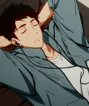 a man wearing headphones is laying on a couch with his hands behind his head