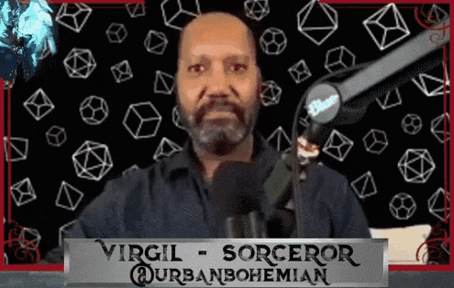 a man with a beard stands in front of a microphone with a sign that says virgil sorceror @urbanbohemian