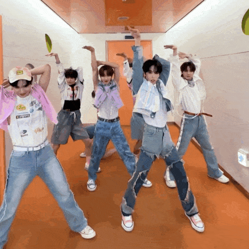 a group of young men are dancing in a hallway and one of them is wearing a shirt that says ' coca cola '