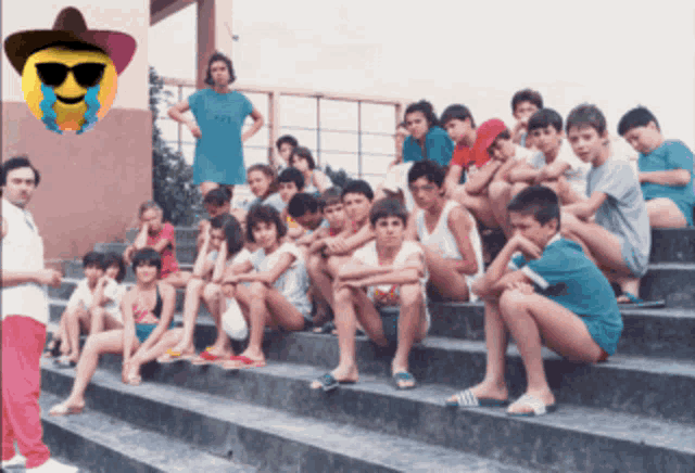 a group of children are sitting on a set of stairs with a smiley face in the background