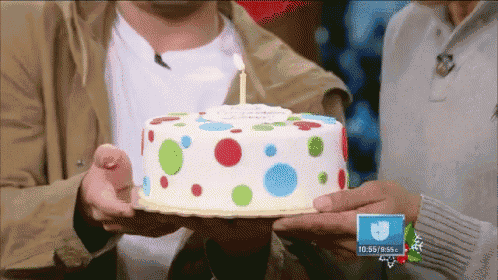 a person holding a birthday cake with a candle on it