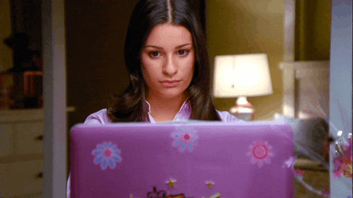 a woman is using a purple laptop with flowers on the cover