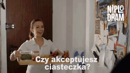 a woman holding a tray of food with the words czy akceptujesz ciasteczka written above her