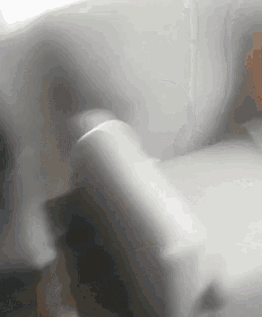 a blurred image of a person 's hand holding a remote control