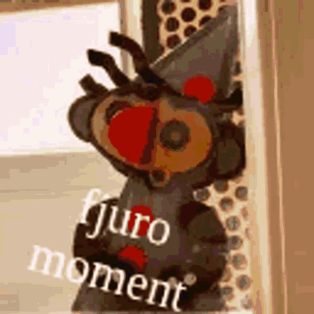 a stuffed animal with a hat on is standing in front of a window .
