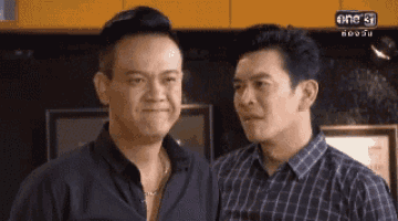 two men are standing next to each other in a room .