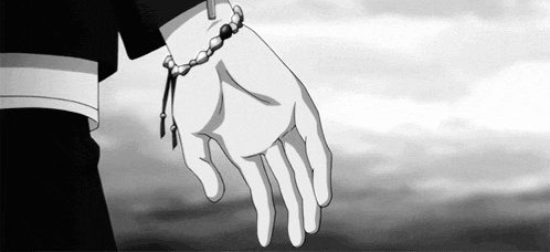 a person wearing a bracelet on their wrist is holding another person 's hand in a black and white photo .