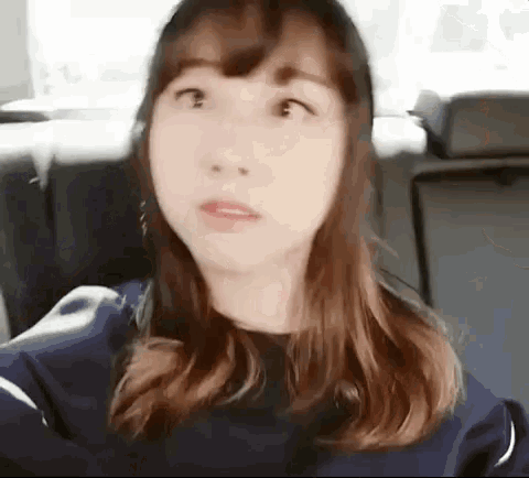 a woman is sitting in the back seat of a car with her eyes closed .