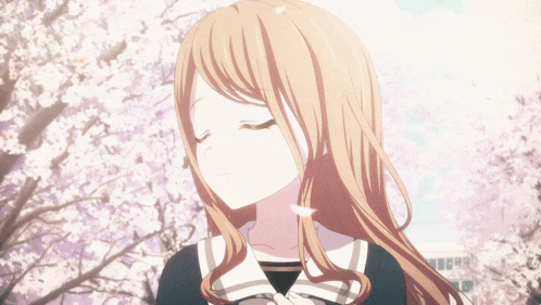 a girl with her eyes closed stands in front of a tree with flowers