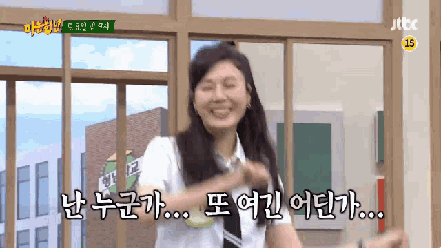 a woman in a school uniform is smiling in front of a window with korean writing on it