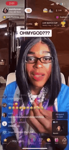 a woman wearing glasses and a blue jacket says ohmygod on a cell phone screen
